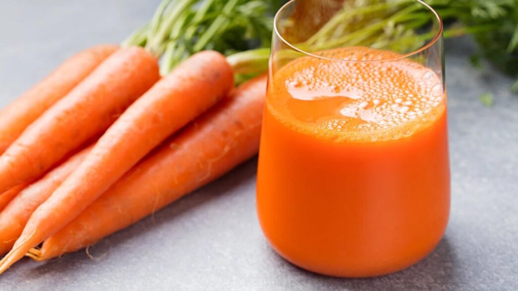 Fresh glass of carrot juice with carrots – benefits of carrots juice for health and energy