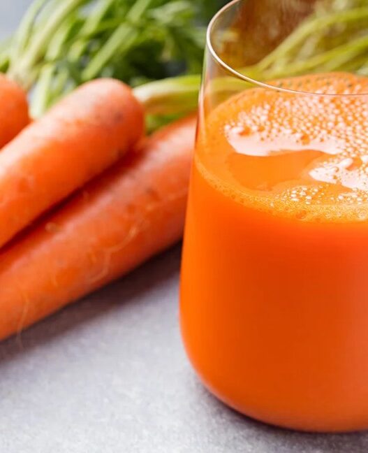 Fresh glass of carrot juice with carrots – benefits of carrots juice for health and energy