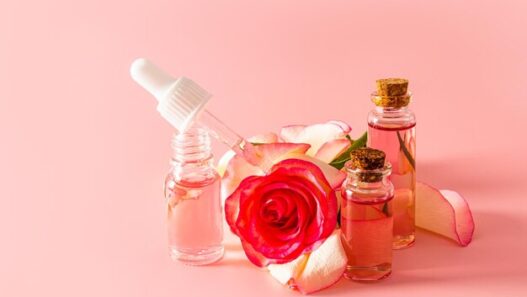 Rose water skin care bottle surrounded by fresh rose petals