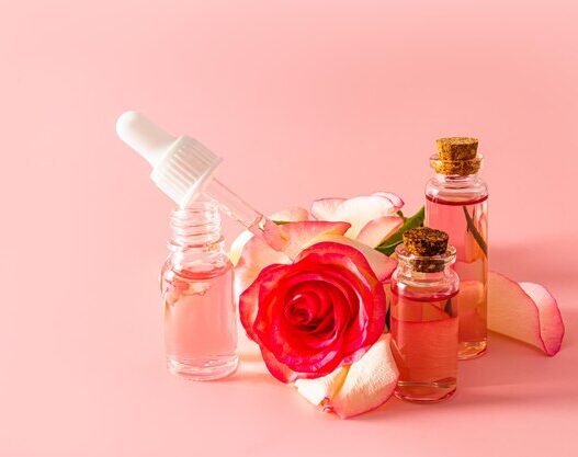 Rose water skin care bottle surrounded by fresh rose petals