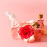 Rose water skin care bottle surrounded by fresh rose petals